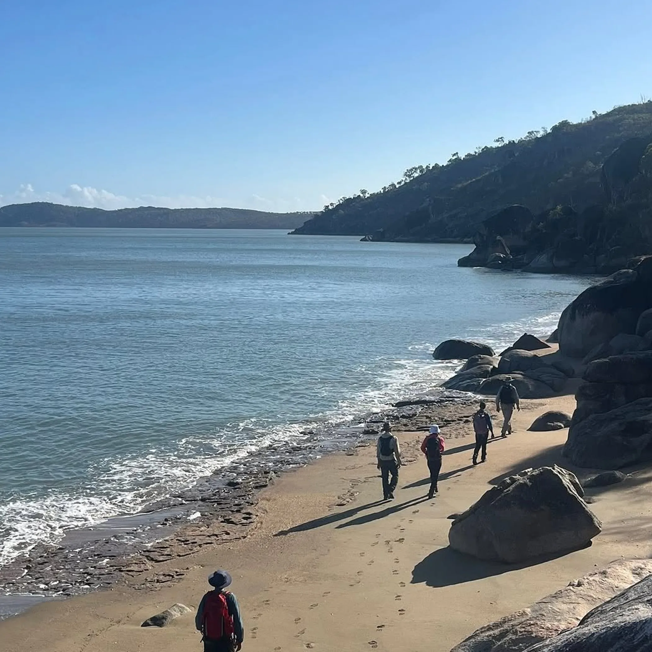 hikers on rugged tropical coastline
